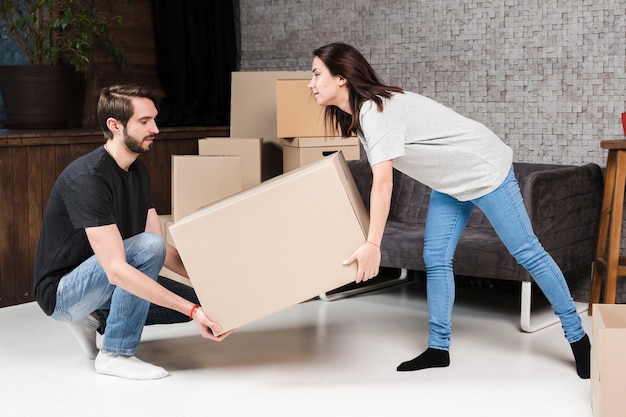 Adult man and woman carrying cardboard boxes