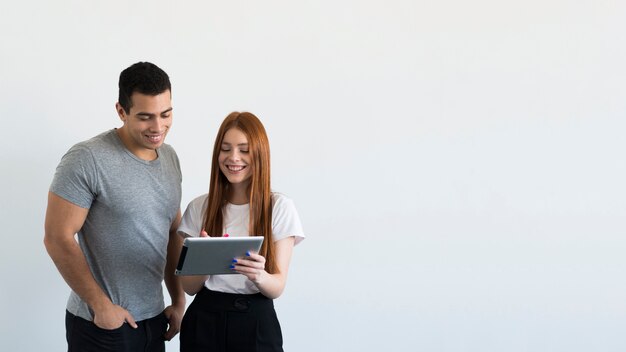 Adult man and woman checking a tablet together