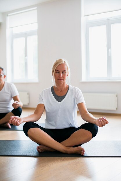 Adult man and woman doing yoga together