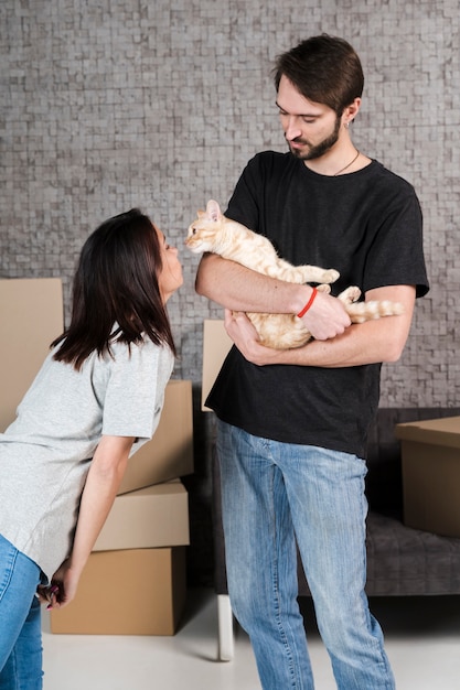 Free photo adult man and woman petting family cat