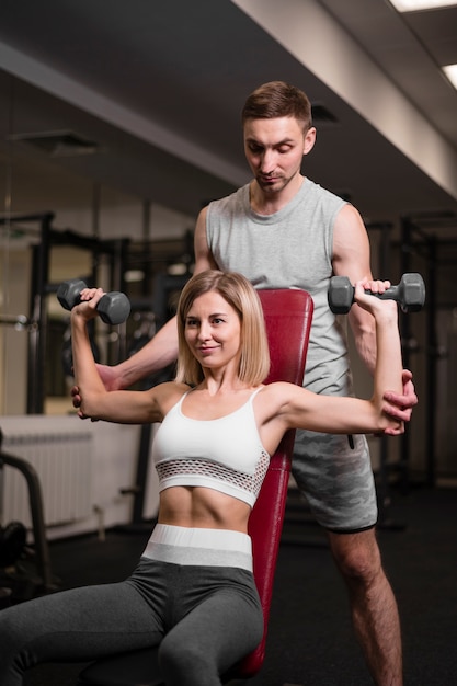 Free photo adult man and woman working out at the gym