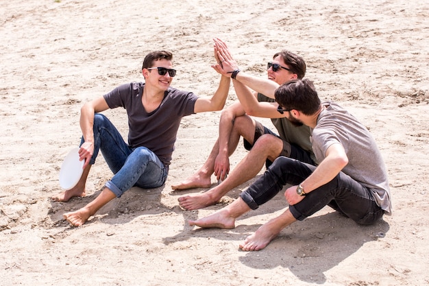 Adult men giving high five to each other