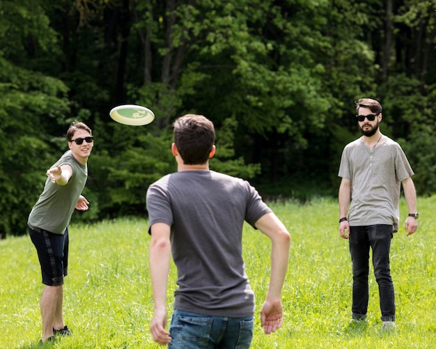 Adult men having fun while playing frisbee