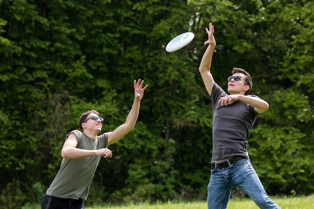 Adult men jumping high for catching frisbee