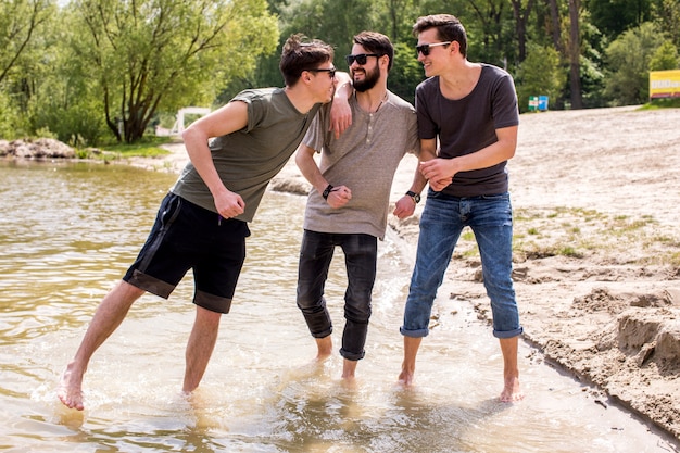 Adult men standing in water and laughing