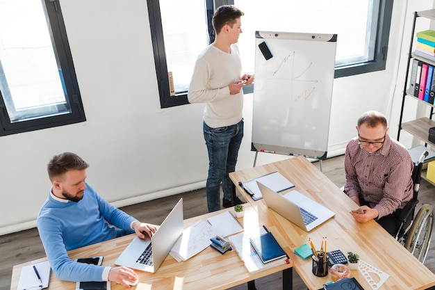 Foto gratuita uomini adulti che lavorano insieme sul progetto