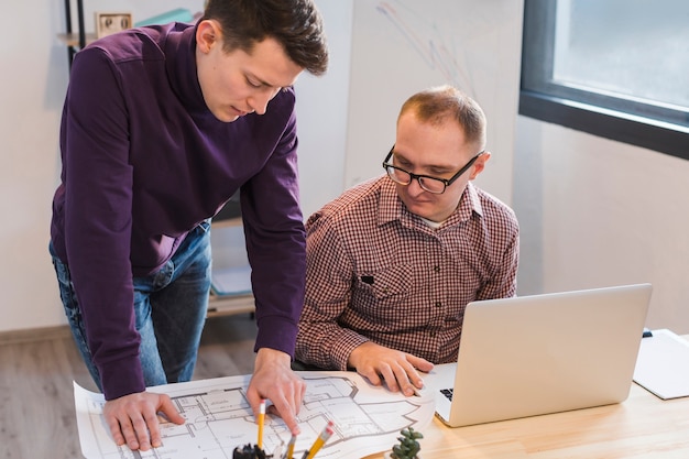 Adult men working together on project