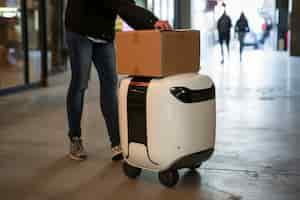 Free photo adult person interacting with futuristic delivery robot