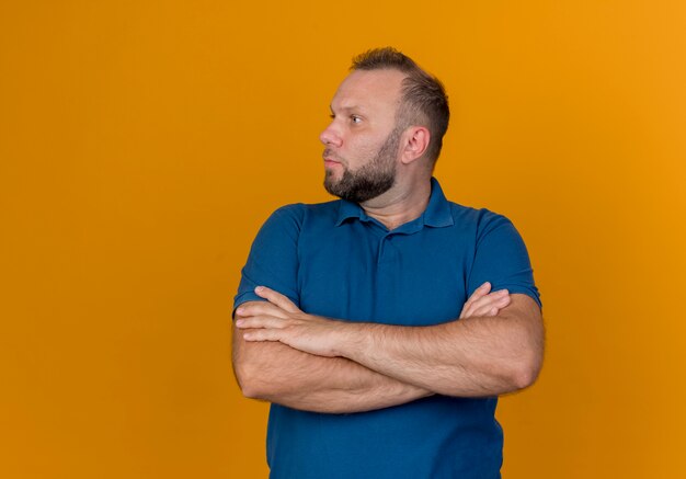 Adult slavic man standing with closed posture looking at side 