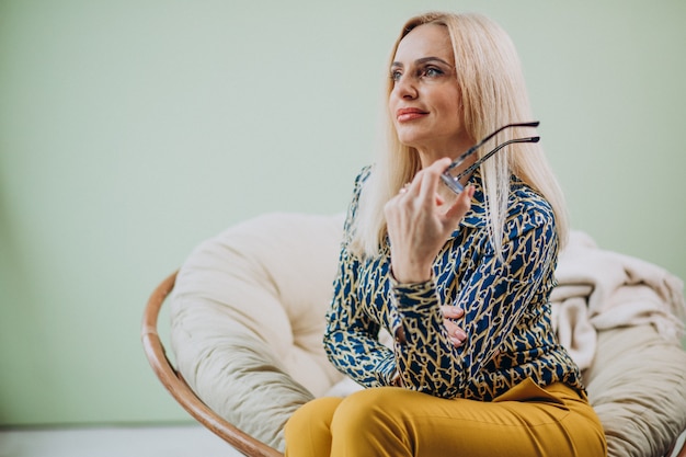 Free photo adult stylish woman sitting in chair