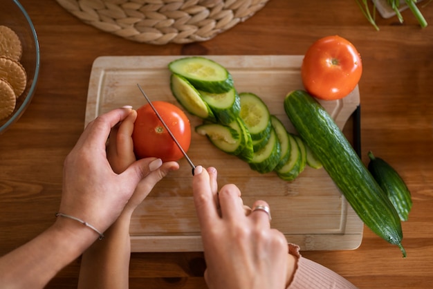 Free photo adult teaching child to cut food with knife