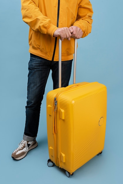 Free photo adult with yellow baggage at studio