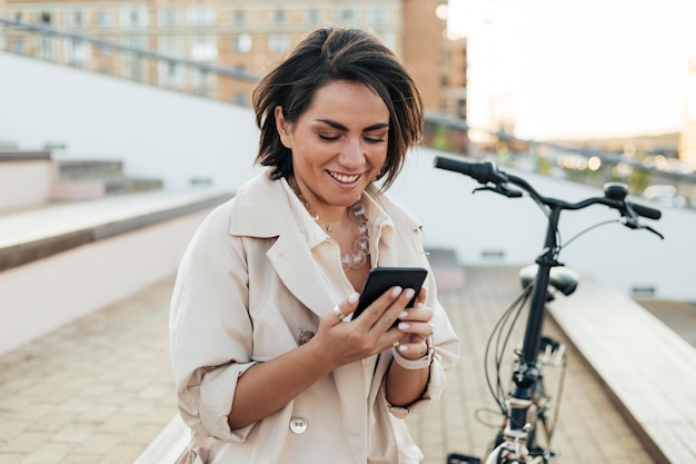 Foto gratuita donna adulta che passa in rassegna il telefono all'aperto