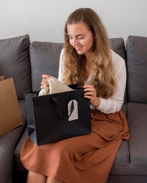 Foto gratuita donna adulta che controlla lo shopping a casa