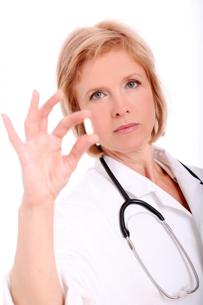 흰색 배경 위에 그녀의 손에 약을 성인 여자 의사