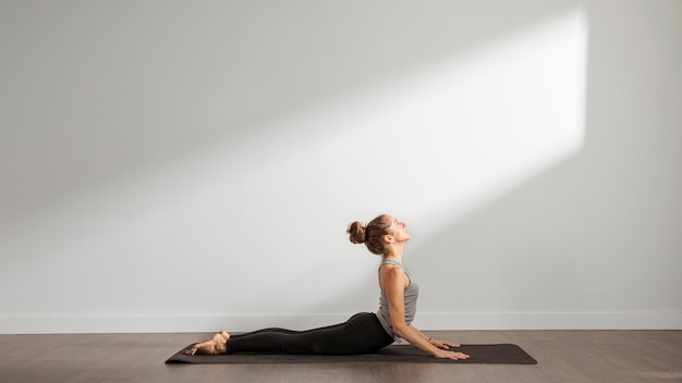Foto gratuita donna adulta che fa yoga a casa