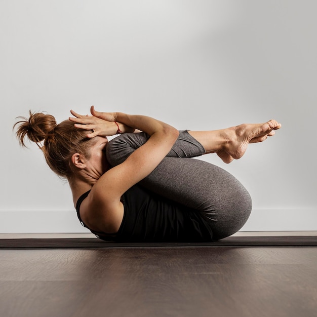 Free photo adult woman doing yoga at home