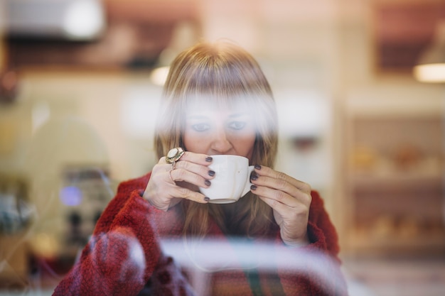 Free photo adult woman enjoying coffee in cafe