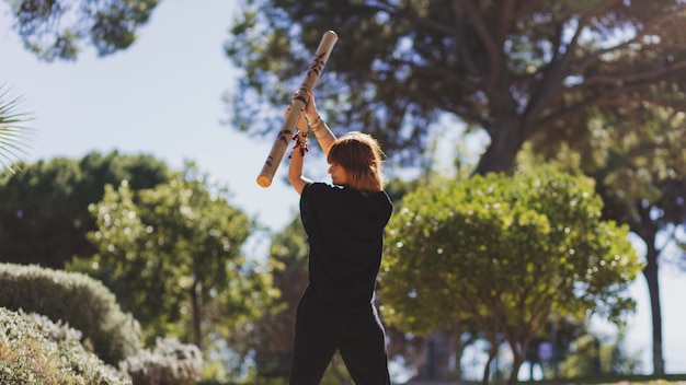 Adult woman exercising with bamboo stick