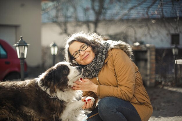 彼女の犬と一緒に庭の大人の女性