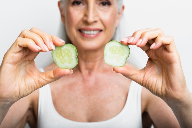 Adult woman holding cucumber slices