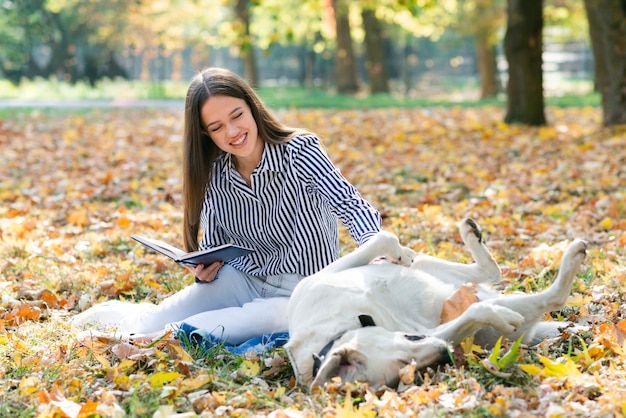 Adult woman petting her dog in the park