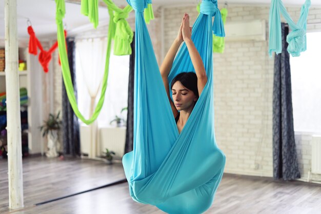 Adult woman practices anti-gravity yoga