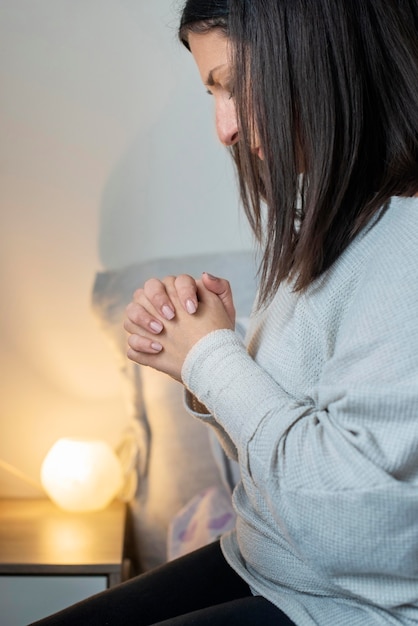 Взрослая женщина молится дома