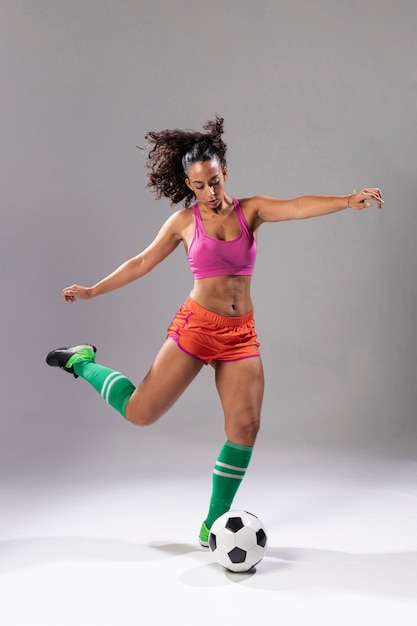 Adult woman in sportswear with soccer ball