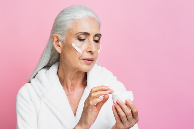 Foto gratuita crema per l'umidità della prova della donna adulta