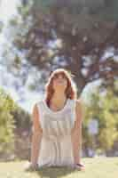 Free photo adult woman in upward-facing dog pose in park