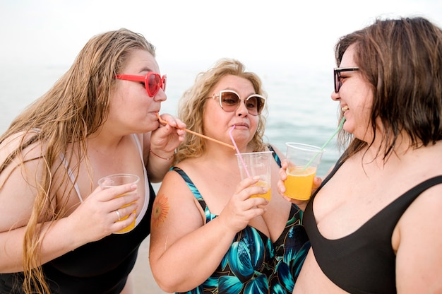 Foto gratuita adulti che bevono succo in spiaggia