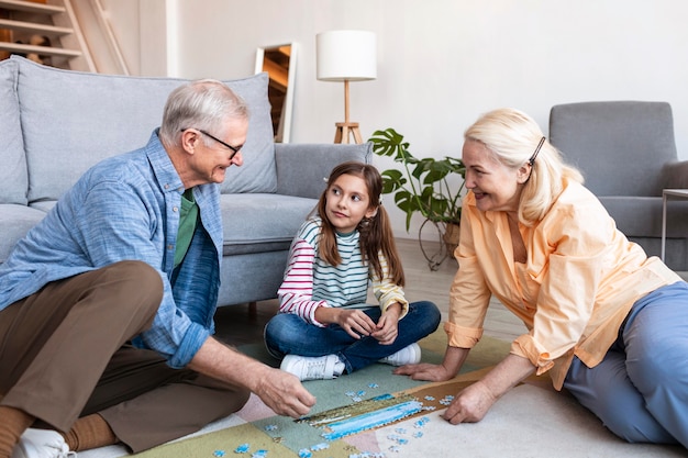 Adults and girl doing puzzle on floor