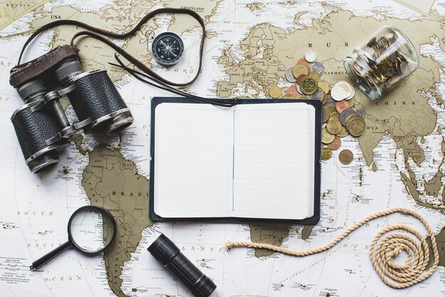 Adventure composition with world map and open notebook