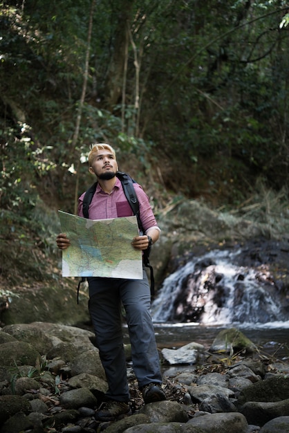 Foto gratuita l'uomo di avventura osserva la mappa su un percorso di montagna per trovare il modo giusto.