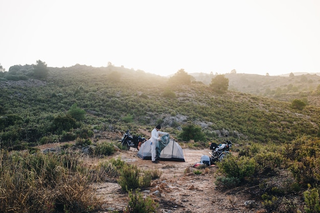 Adventure motorcyclist camping in wild