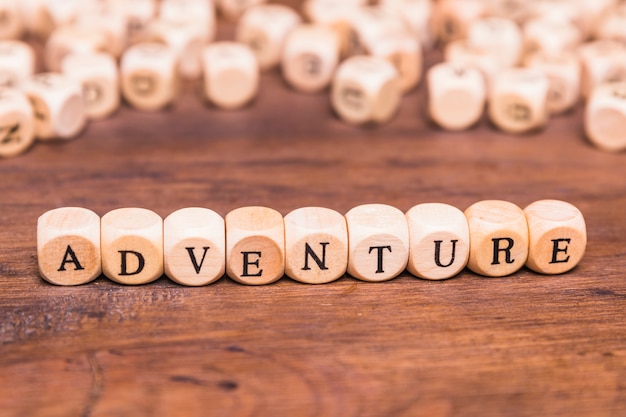 Free photo adventure text arranged with wooden cubes