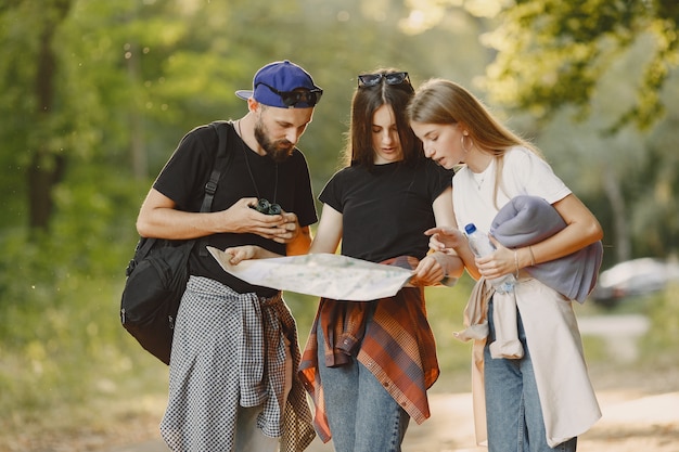 Free photo adventure, travel, tourism, hike and people concept. group of smiling friends in a forest.