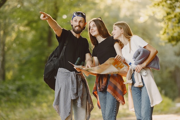 Adventure, travel, tourism, hike and people concept. Group of smiling friends in a forest.