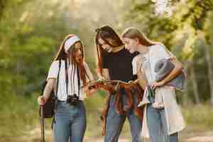 Free photo adventure, travel, tourism, hike and people concept. three girls in a forest.