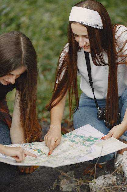 Adventure, travel, tourism, hike and people concept. Three girls in a forest.