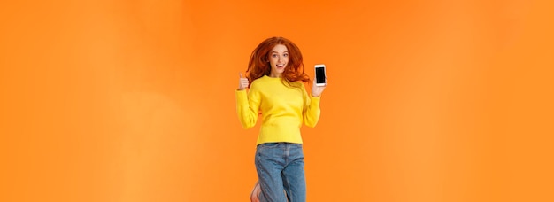 Бесплатное фото Рекламные технологии и концепция праздников вертикальный снимок в полный рост веселая великолепная рыжая девушка р