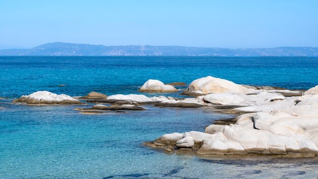 물 위에 바위와 땅 푸른 물, 그리스에게 해 해안