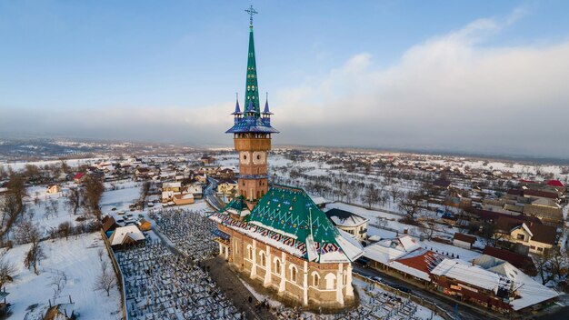 Aerial drone view of The Merry Cemetery in Sapanta in winter Romania Multiple tombstones church snow