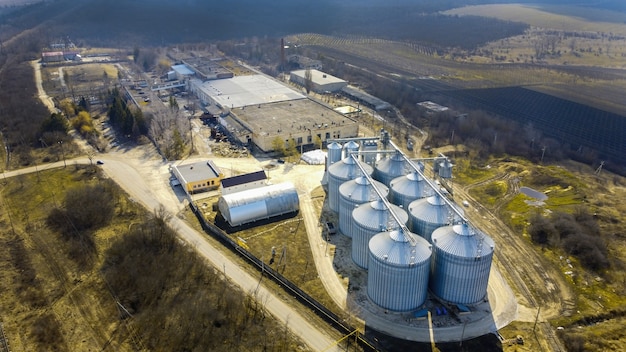 Aerial drone view of a winery metal cisterns with bare trees and fields around it in Moldova