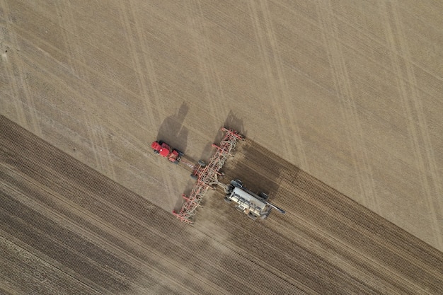 Aerial overhead shot of fertilizer machine in a farming field during daytime