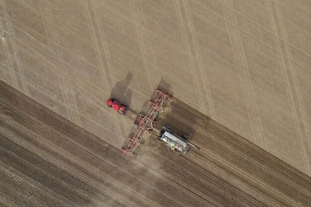 Aerial overhead shot of fertilizer machine in a farming field during daytime