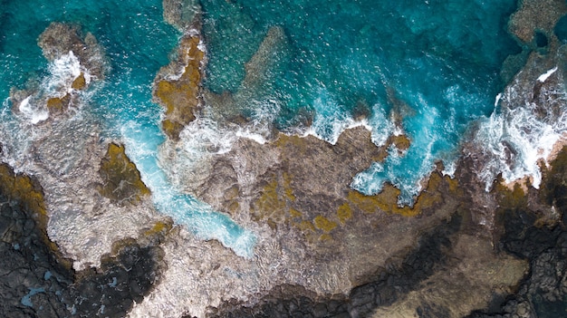 Aerial overhead shot of sea with rocky coastline
