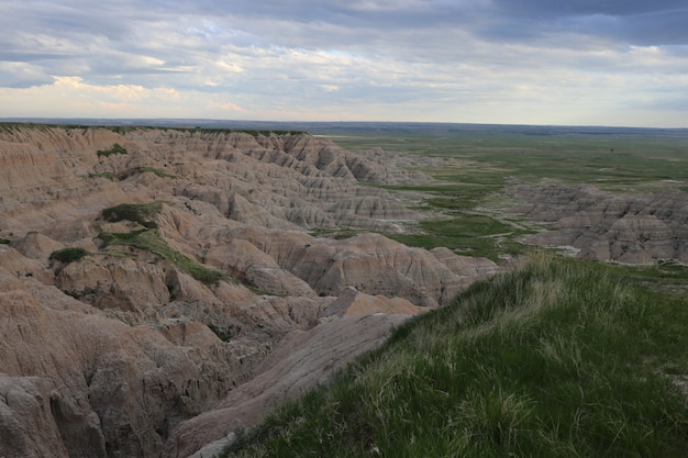 Aerial shot of badlands with grassy fields