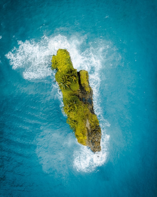 海の真ん中にある美しい緑の小さな島の空中ショット